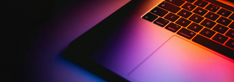 A laptop highlighted by the colours coming from the screen