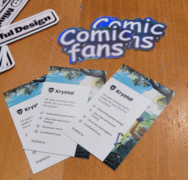 Three Krystal cards with some of our features are on a table, next to some Mindful Design and Comic Fans stickers
